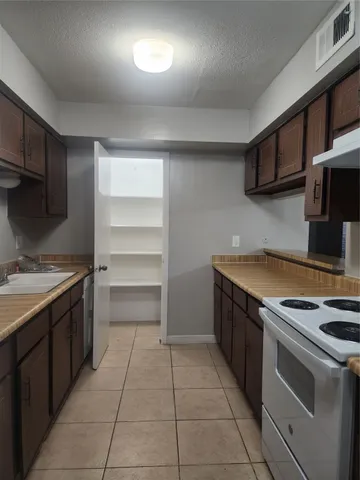 a kitchen with a cabinets and a stove top oven