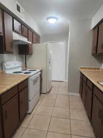 a kitchen with a sink a stove and a refrigerator