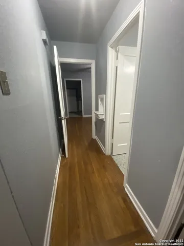 a view of a hallway with wooden floor