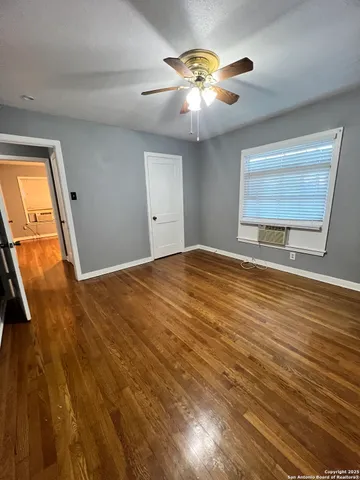 a view of an empty room and chandelier fan
