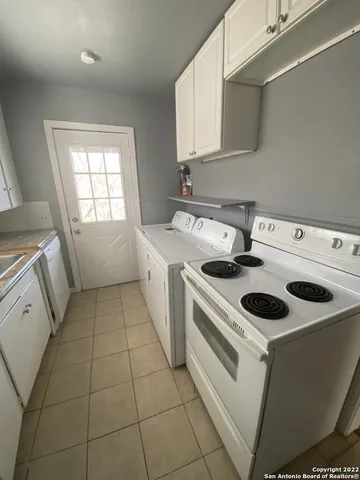 a kitchen with a stove sink and cabinets