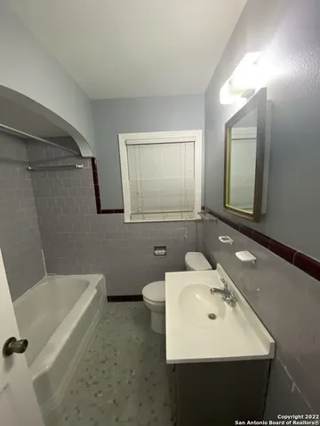 a bathroom with a sink mirror and a bathtub