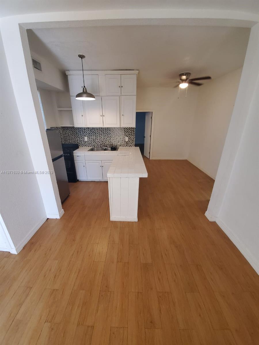 7149 Bay Drive, Unit 2 Miami Beach, FL 33141 - Photo 2 of 15 a kitchen with a wooden floor and electronic appliances