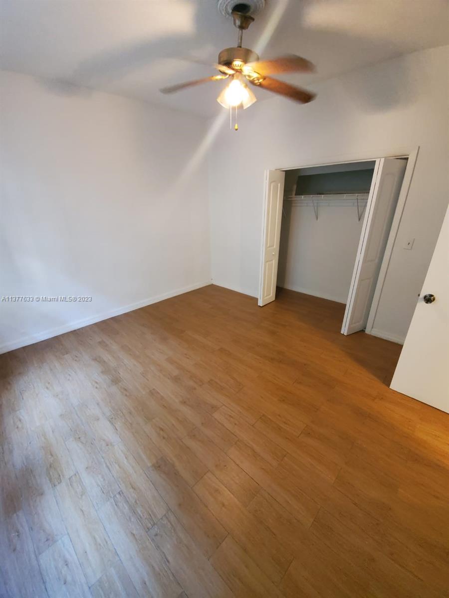 7149 Bay Drive, Unit 2 Miami Beach, FL 33141 - Photo 8 of 15 a view of a big room with wooden floor a ceiling fan and window