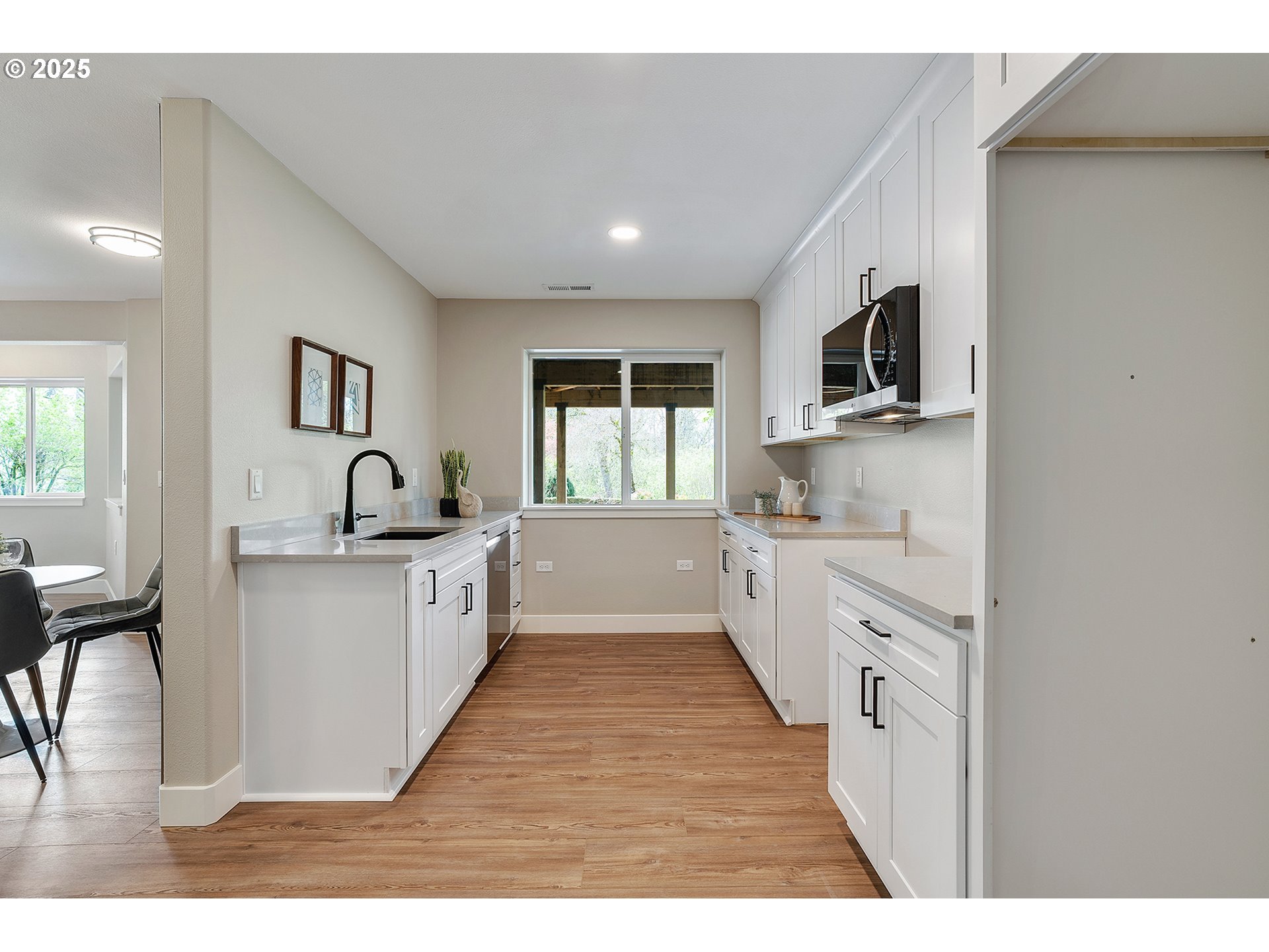 655 Barbary Place Gladstone, OR 97027 - Photo 33 of 48 a large white kitchen with kitchen island a sink a window and a stove