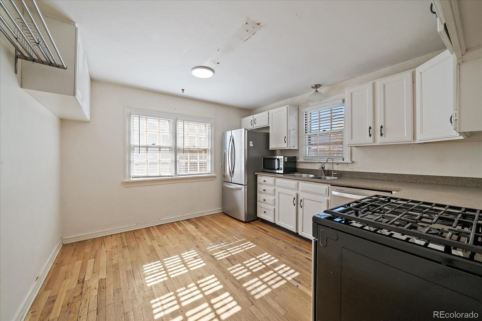 2575 South Lafayette Street Denver, CO 80210 - Photo 6 of 25 a kitchen with a refrigerator a stove a sink and a window