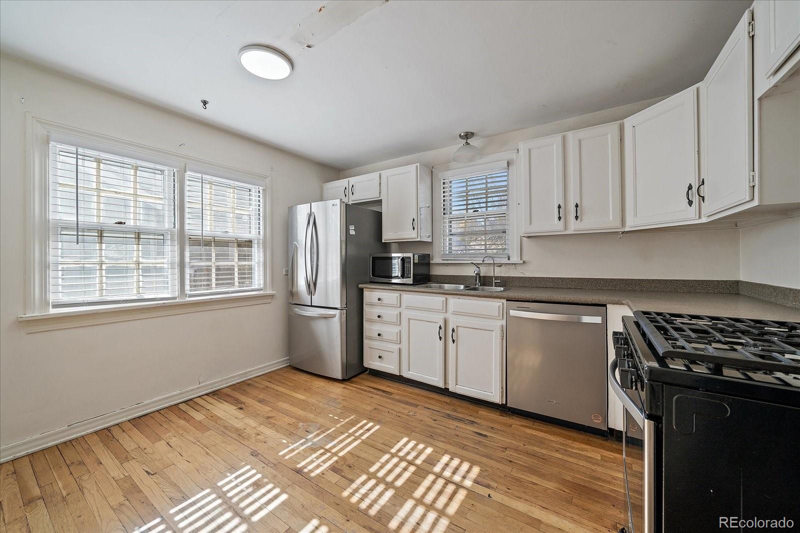 2575 South Lafayette Street Denver, CO 80210 - Photo 7 of 25 a kitchen with granite countertop a refrigerator stove top oven and cabinets