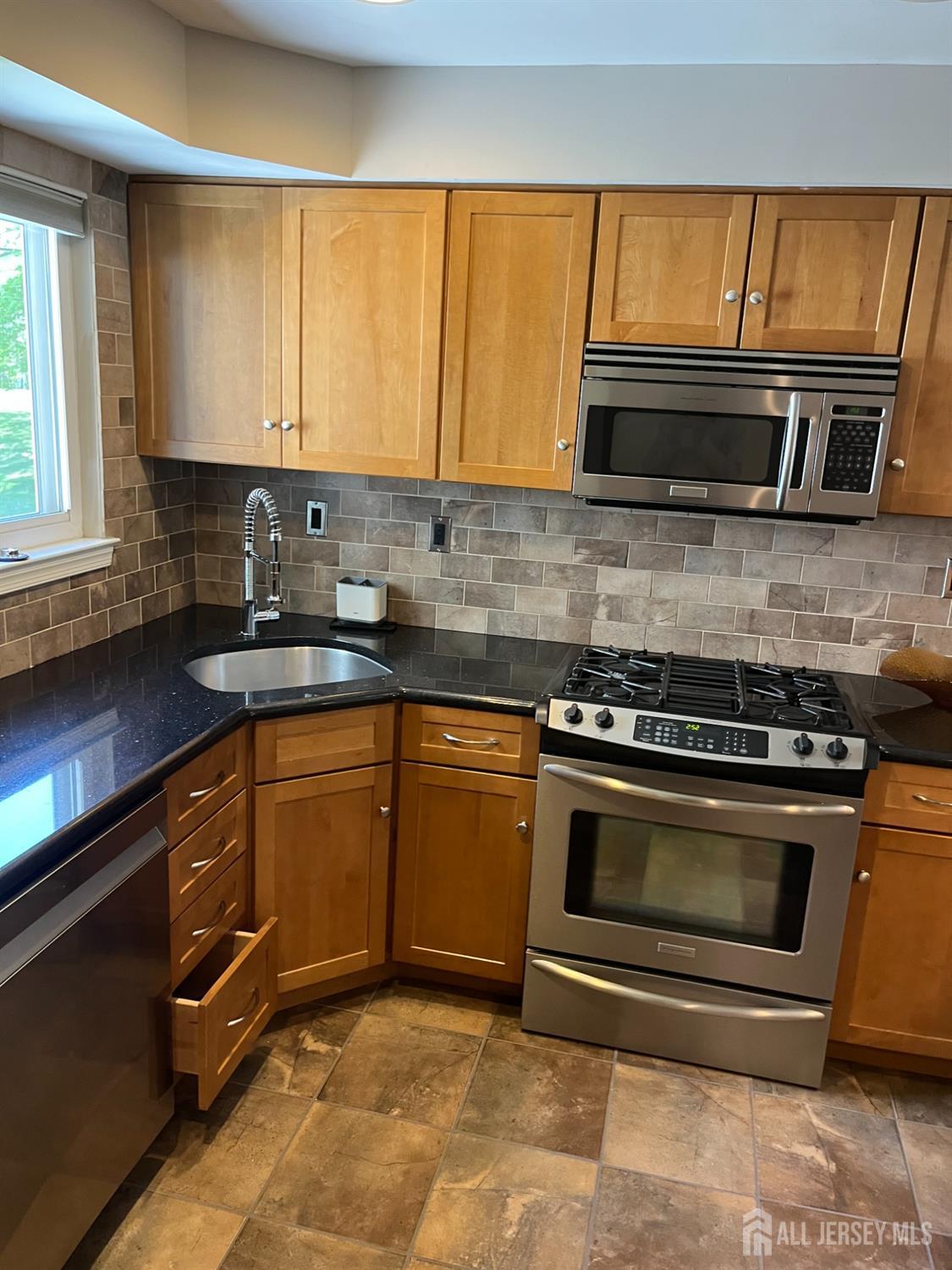 511 Chanticleer Cherry Hill, NJ 08003 - Photo 11 of 20 a kitchen with granite countertop a stove a sink and a microwave