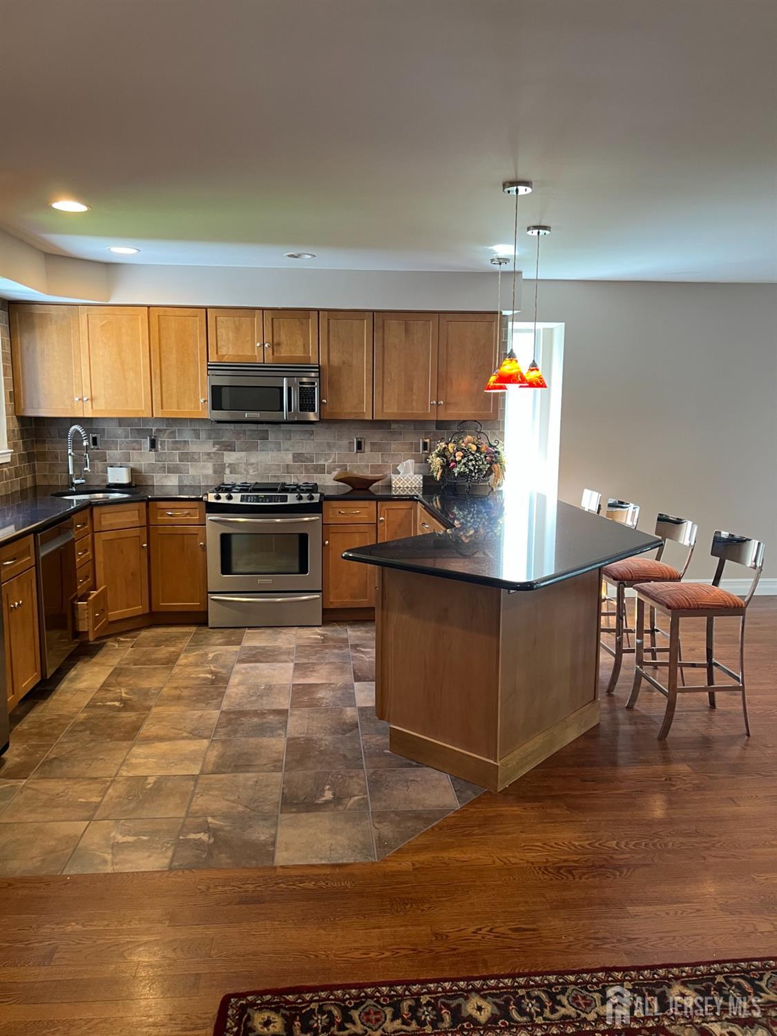 511 Chanticleer Cherry Hill, NJ 08003 - Photo 18 of 20 a kitchen with stainless steel appliances granite countertop a stove top oven a sink dishwasher and cabinets with wooden floor
