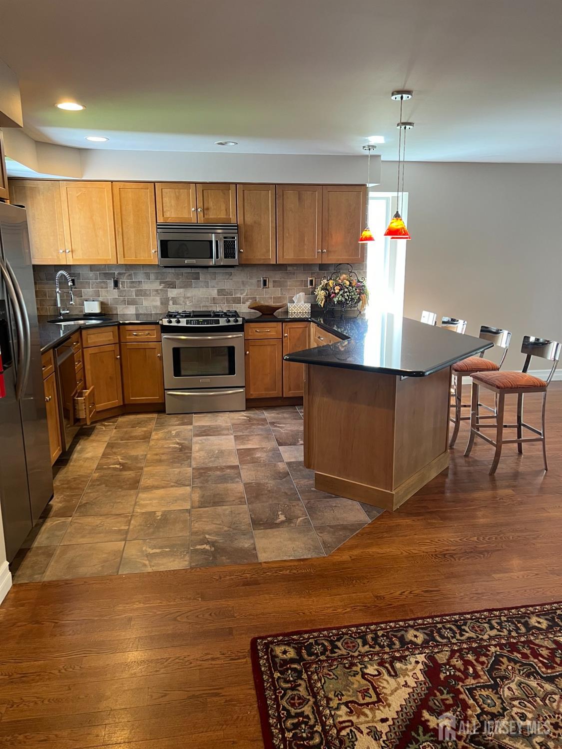 511 Chanticleer Cherry Hill, NJ 08003 - Photo 19 of 20 a kitchen with stainless steel appliances granite countertop a stove a sink and a microwave