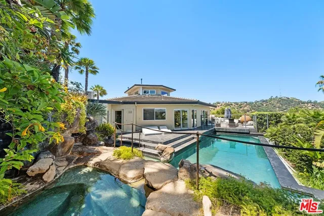 a view of a swimming pool with lounge chairs in patio