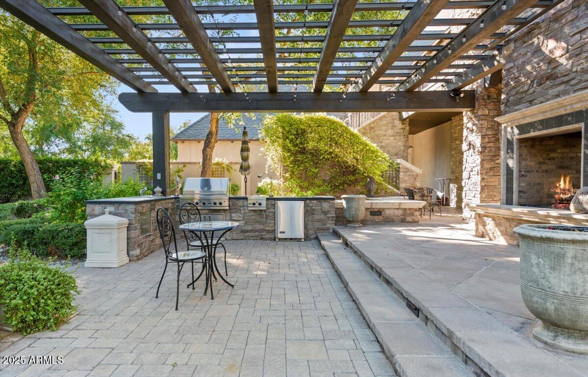 2205 East Colter Street Phoenix, AZ 85016 - Photo 40 of 59 a view of a patio with dining table and chairs with wooden floor and fence