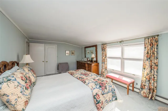 a bedroom with a bed couch and a window