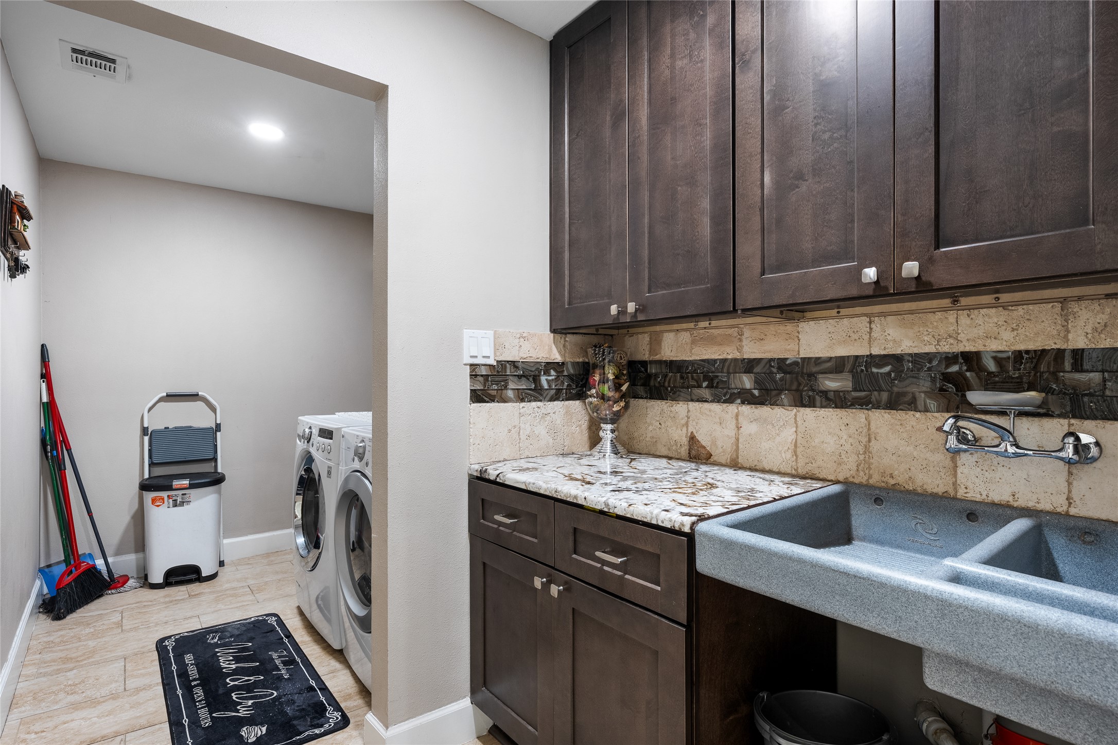 301 Oak Ridge Road Georgetown, TX 78628 - Photo 9 of 38 Laundry area featuring wood-finish cabinetry, granite-style countertop, and a utility sink