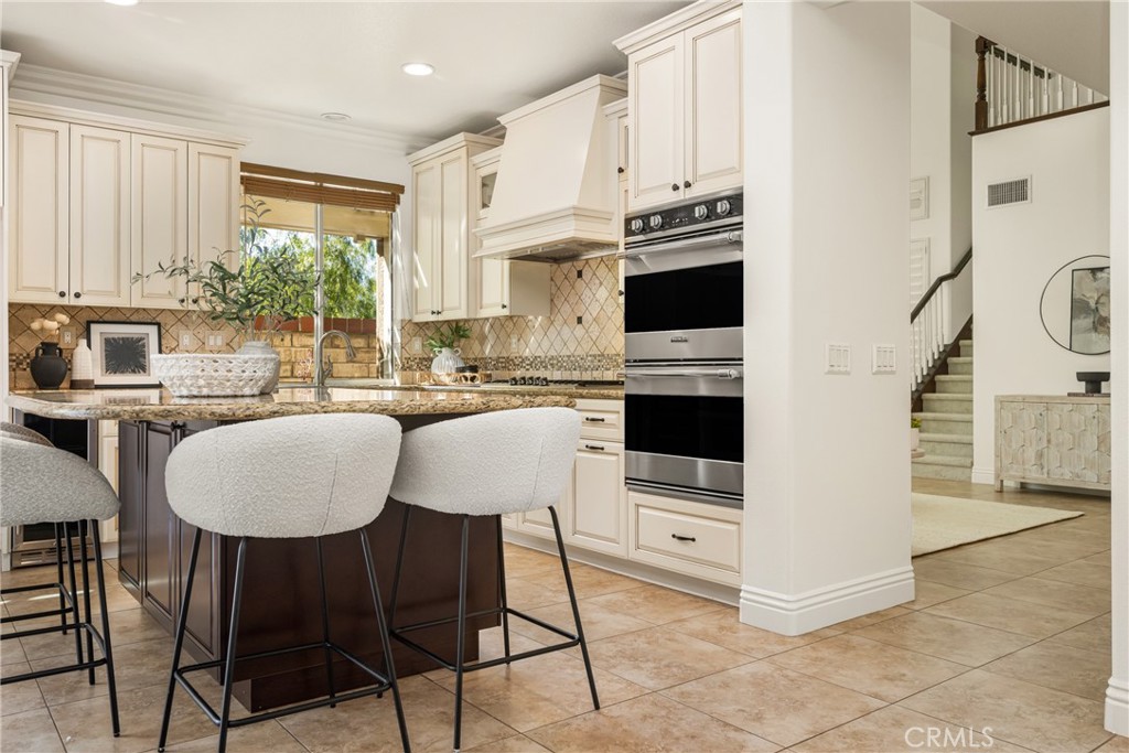 10970 Hiskey Lane Tustin, CA 92782 - Photo 21 of 60 a kitchen with stainless steel appliances a stove a refrigerator a microwave a sink and white cabinets