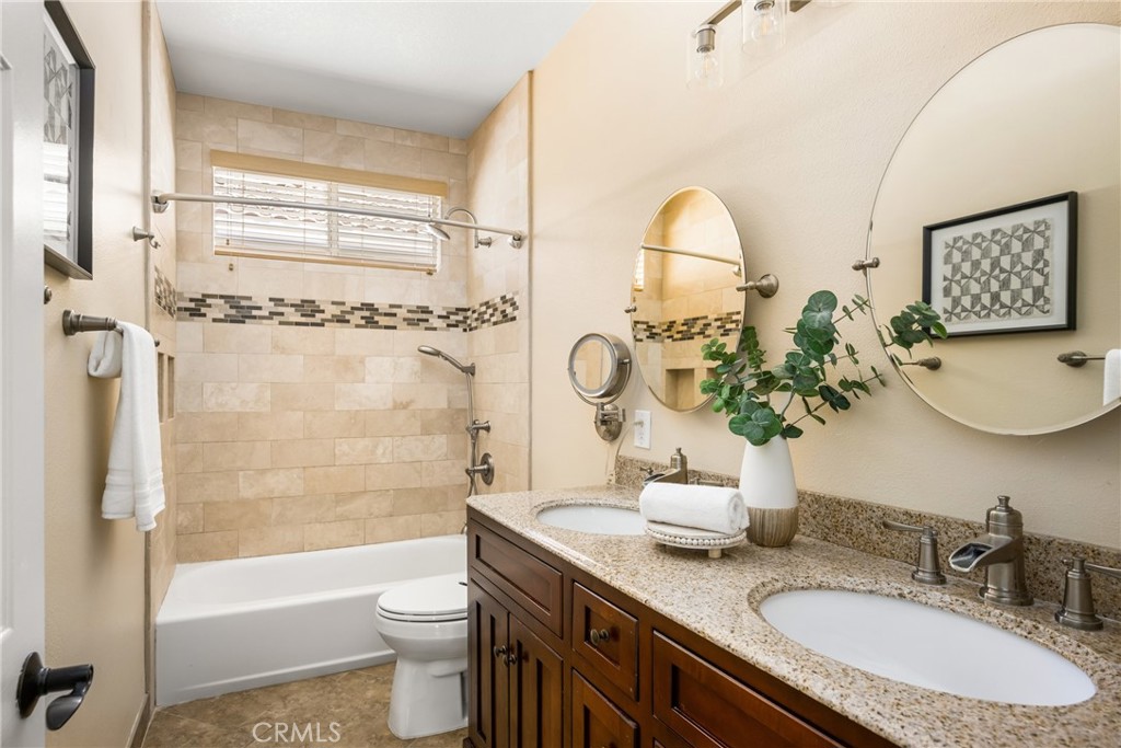 10970 Hiskey Lane Tustin, CA 92782 - Photo 53 of 60 a bathroom with a granite countertop sink a toilet a mirror and shower