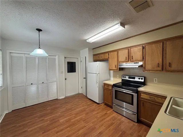 a kitchen with granite countertop a stove and a refrigerator