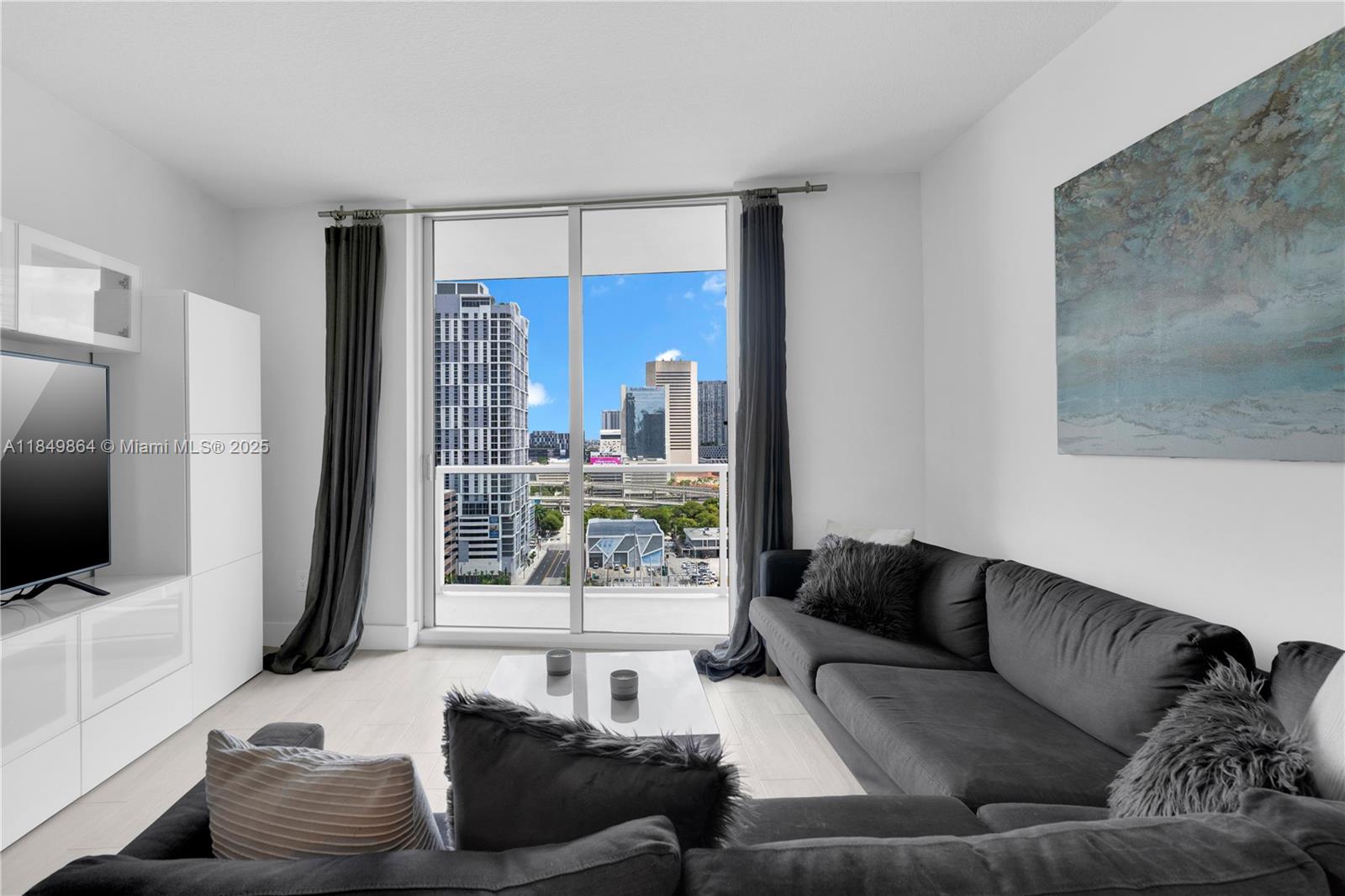 185 Southwest 7th Street, Unit 1901 Miami, FL 33130 - Photo 13 of 46 a living room with furniture and a flat screen tv