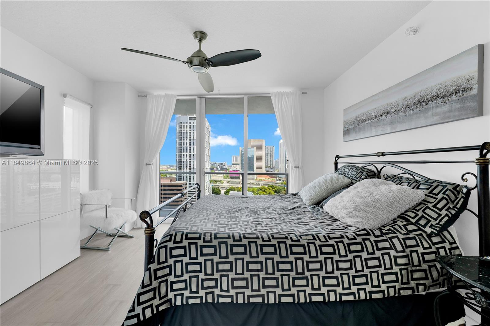 185 Southwest 7th Street, Unit 1901 Miami, FL 33130 - Photo 15 of 46 a bedroom with a bed window and a flat screen tv