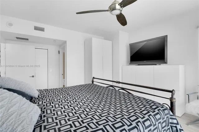 a bedroom with a bed and flat screen tv