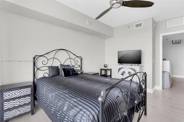 a bedroom with a bed and a flat tv screen on wall
