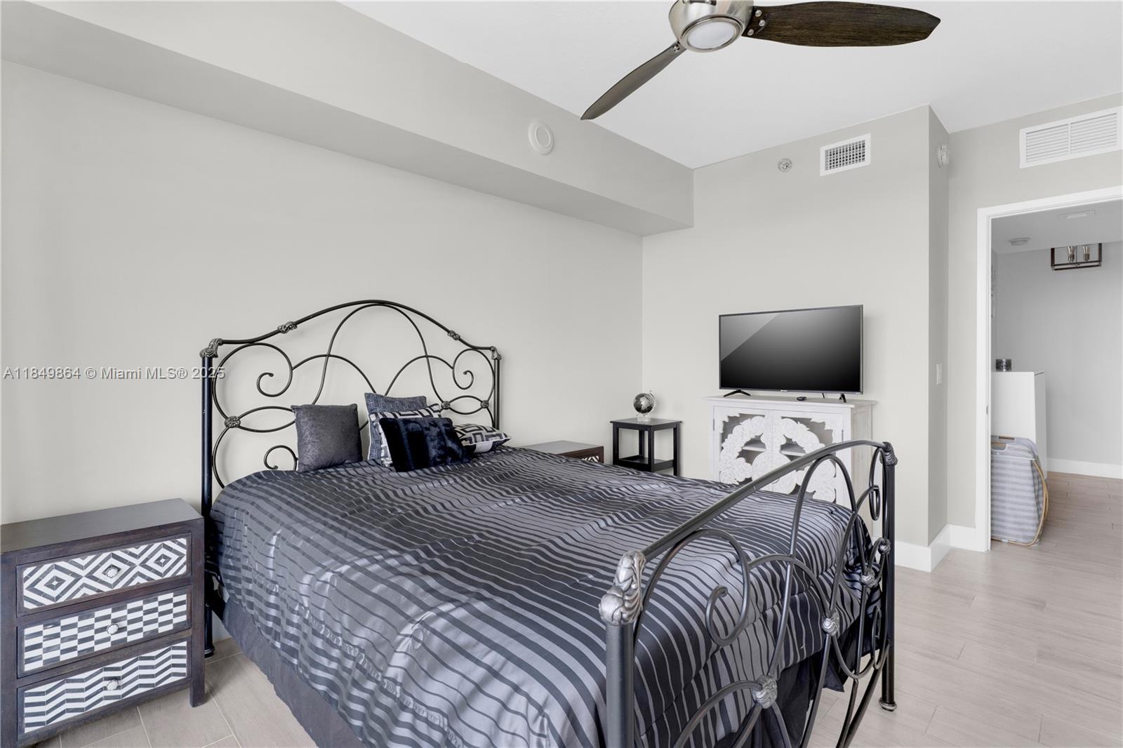 185 Southwest 7th Street, Unit 1901 Miami, FL 33130 - Photo 24 of 46 a bedroom with a bed and a flat tv screen on wall