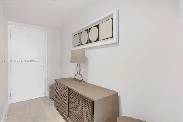 a view of a hallway with wooden floor and closet