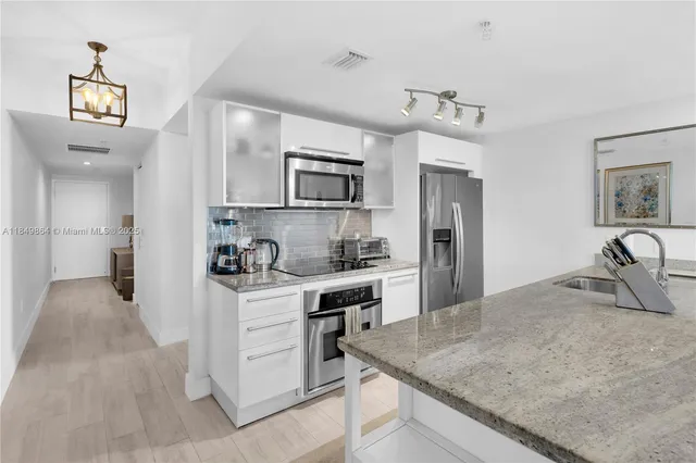 a kitchen with kitchen island a sink stove and refrigerator