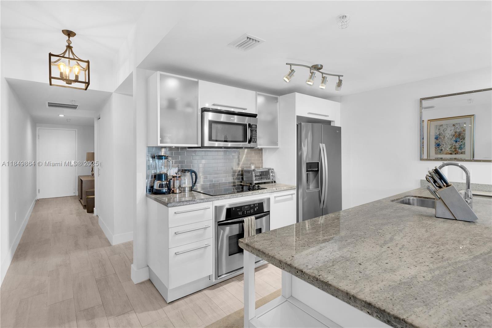185 Southwest 7th Street, Unit 1901 Miami, FL 33130 - Photo 4 of 46 a kitchen with kitchen island a sink stove and refrigerator