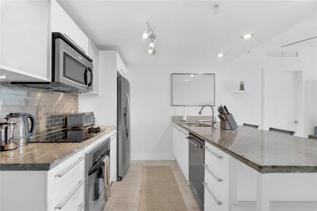a kitchen with stainless steel appliances granite countertop a sink stove and cabinets