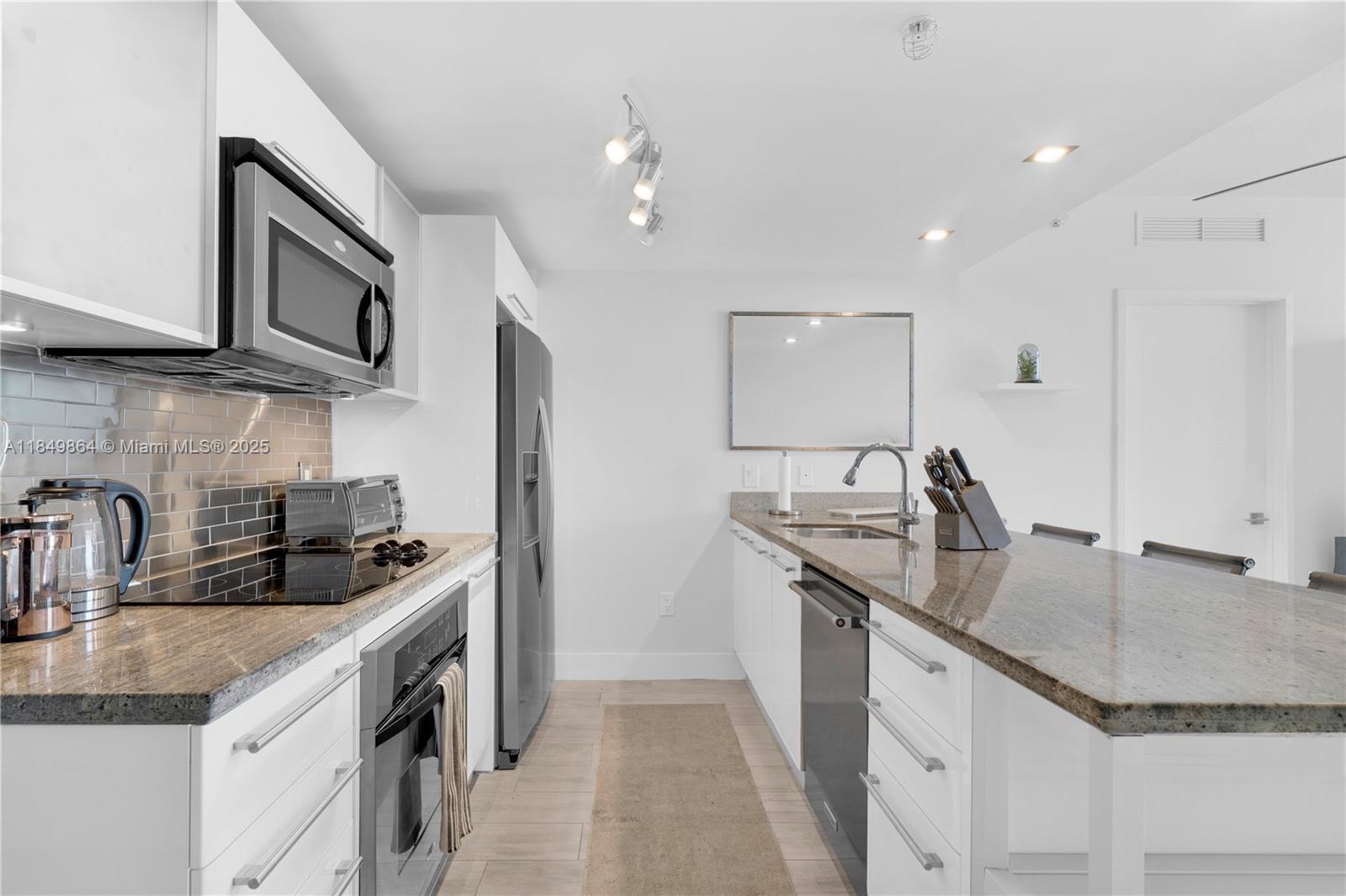 185 Southwest 7th Street, Unit 1901 Miami, FL 33130 - Photo 8 of 46 a kitchen with stainless steel appliances granite countertop a sink stove and cabinets