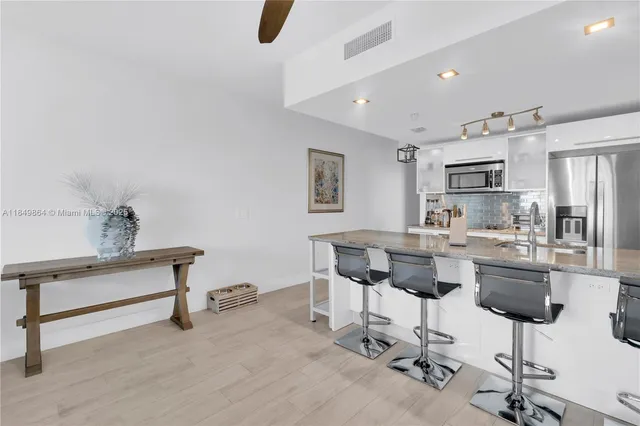 a kitchen with cabinets and chairs
