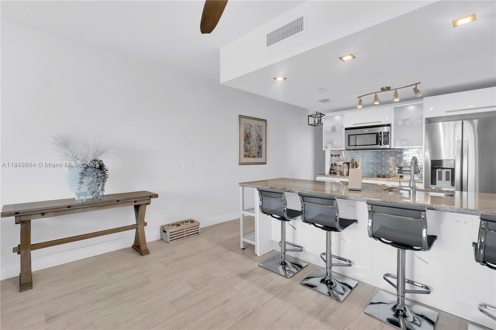 185 Southwest 7th Street, Unit 1901 Miami, FL 33130 - Photo 9 of 46 a kitchen with cabinets and chairs