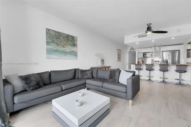 a living room with furniture and a view of kitchen
