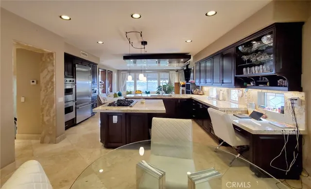 a kitchen with stainless steel appliances granite countertop a sink a stove and a refrigerator