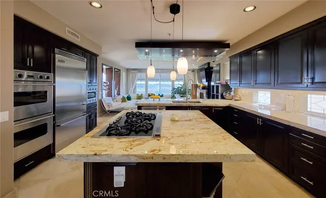 a view of a kitchen island a sink wooden floor and a refrigerator