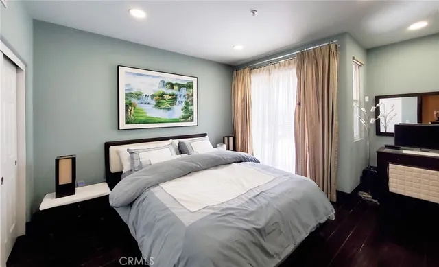 a bedroom with bed and wooden floor