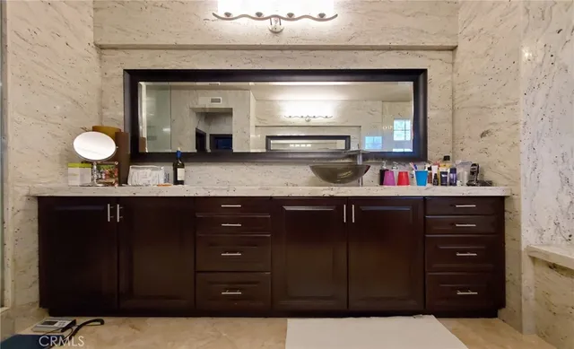 a spacious bathroom with a sink double vanity granite tub shower and a mirror