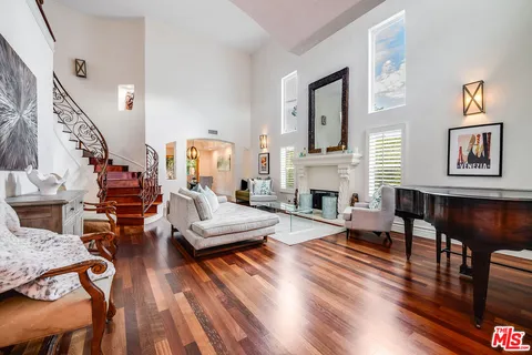 a living room with furniture fireplace and wooden floor
