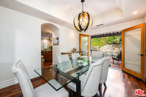 a dining room with furniture a potted plant and wooden floor