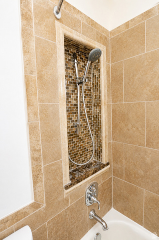 1055 North 1000 East Mapleton, UT 84664 - Photo 61 of 112 Bathtub shower combination featuring large format wall tiling, a mosaic-tiled shower niche with a stone shelf, and a polished chrome faucet and shower head