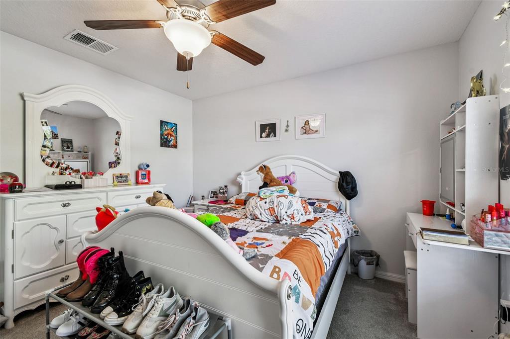 8439 Hunters Fork Loop Ruskin, FL 33573 - Photo 13 of 74 a bedroom with a bed and a chandelier