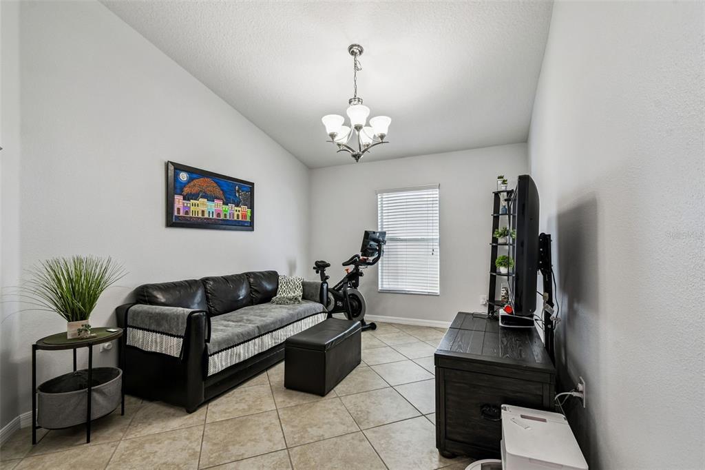 8439 Hunters Fork Loop Ruskin, FL 33573 - Photo 14 of 74 a living room with furniture a chandelier and a window
