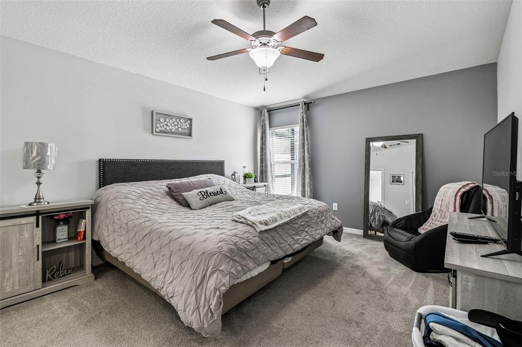 8439 Hunters Fork Loop Ruskin, FL 33573 - Photo 34 of 74 a bedroom with a bed and a chandelier