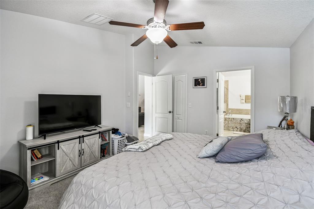 8439 Hunters Fork Loop Ruskin, FL 33573 - Photo 35 of 74 a bedroom with a bed and a flat screen tv