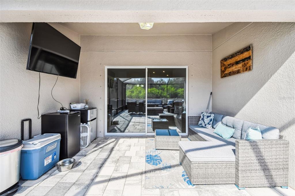 8439 Hunters Fork Loop Ruskin, FL 33573 - Photo 42 of 74 a living room with furniture a flat screen tv and a floor to ceiling window