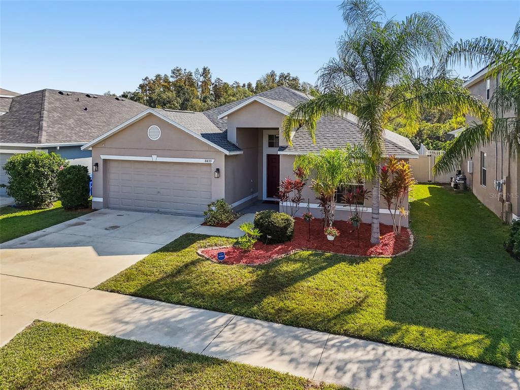 8439 Hunters Fork Loop Ruskin, FL 33573 - Photo 54 of 74 a view of a house with a swimming pool and a garden