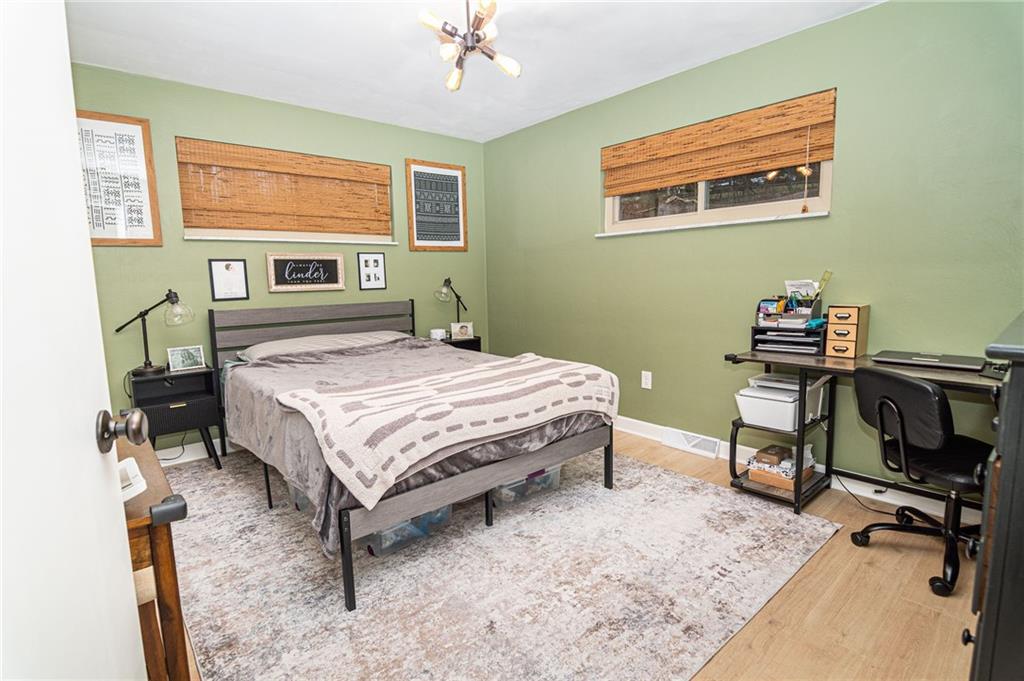 1005 Paintertown Road Irwin, PA 15642 - Photo 8 of 33 a bedroom with a bed a desk and chair with wooden floor