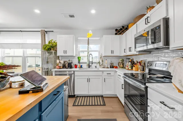 a living room with kitchen island furniture and a chandelier