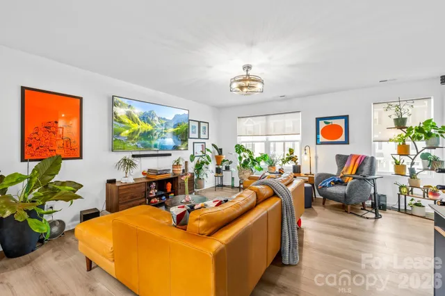 a living room with furniture a window and a flat screen tv
